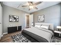 Modern bedroom with ceiling fan, black and white furniture, light gray walls, and wood-look flooring at 1175 S Gilbert St, Castle Rock, CO 80104