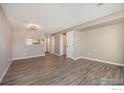 Bright, open living room with wood-look floors and a view into the adjacent kitchen area at 1175 S Gilbert St, Castle Rock, CO 80104