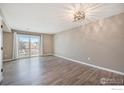 Bright living room with sliding glass doors, leading to a balcony, light tan walls and wood-look flooring at 1175 S Gilbert St, Castle Rock, CO 80104