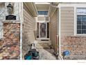 A welcoming front entryway with stone pillars and a charming front door at 13832 Legend Way # 102, Broomfield, CO 80023