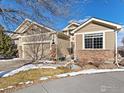 Home exterior featuring stone accents, large picture window, attached garage and well-manicured lawn at 13832 Legend Way # 102, Broomfield, CO 80023