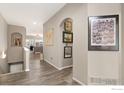 A hallway leading into a living room, with art pieces adorning the neutral colored walls at 13832 Legend Way # 102, Broomfield, CO 80023