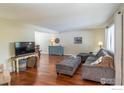 Bright living room featuring hardwood floors, a comfortable gray couch and neutral paint at 1400 Athene Dr, Lafayette, CO 80026