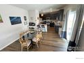 A dining area with wood floors, a glass table, and seating for eight, next to the kitchen at 14860 Guernsey Dr, Mead, CO 80542