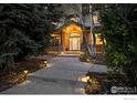 Inviting front entrance with stone accents, a covered porch, and a well-lit walkway at 1574 Carlson Ave, Erie, CO 80516