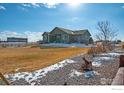 Back exterior showing spacious fenced in yard with manicured gravel, lawn and patio space at 16504 N Fairbanks N Rd, Platteville, CO 80651