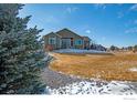 View of back exterior, showcasing a well-maintained yard, patio and gravel pathway at 16504 N Fairbanks N Rd, Platteville, CO 80651