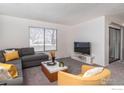 Comfortable living room featuring neutral tones, large window, and modern furnishings at 1905 Chalcis Dr # A, Lafayette, CO 80026