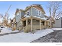 Charming two-story home with covered porch, gray siding, and snow-covered landscape at 1944 Arapahoe Ave # C, Boulder, CO 80302