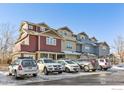 Street view featuring a row of townhomes with varied colors and ample parking spaces at 1944 Arapahoe Ave # C, Boulder, CO 80302