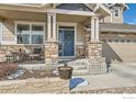 Inviting front porch with stone accents and a decorative wreath on the front door at 2289 French Cir, Longmont, CO 80504