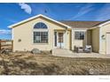 Inviting single-Gathering home with a well-kept lawn, large window, and cozy seating area on the front porch at 4700 Karen Ct, Berthoud, CO 80513