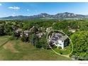 Aerial view of the home with solar panels, set against a backdrop of lush greenery and mountains at 5656 Cascade Pl, Boulder, CO 80303