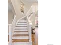 Elegant curved staircase with white railings and hardwood treads, bathed in natural light at 5656 Cascade Pl, Boulder, CO 80303