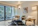 A modern living room with a sliding glass door to a patio area, furnished with two comfortable chairs and a rug at 60 S Boulder Cir # 6015, Boulder, CO 80303