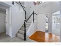 Bright foyer featuring hardwood floors, carpeted stairs, and white trim at 602 S 34Th Ave, Brighton, CO 80601