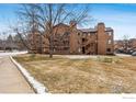 Condo complex exhibits exterior wooden stairways and a lawn at 6118 Habitat Dr # 1, Boulder, CO 80301