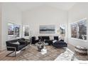 Bright living room featuring vaulted ceilings, wood floors, and contemporary decor at 6924 Quigley Cir, Firestone, CO 80504