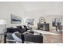 Bright living room featuring vaulted ceilings, wood floors, fireplace, and contemporary decor at 6924 Quigley Cir, Firestone, CO 80504