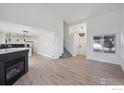 Open concept living space seamlessly connects the kitchen and living area, with a cozy fireplace at 6924 Quigley Cir, Firestone, CO 80504