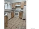 Bright kitchen featuring white appliances, light wood cabinets, and ample counter space at 710 Copper Ln # 102, Louisville, CO 80027