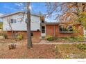 Brick home with covered entryway surrounded by mature trees and autumn foliage at 845 Hartford Dr, Boulder, CO 80305