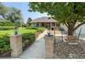 Welcoming front entrance with brick columns, lanterns, and landscaped walkway at 1314 Highway 66, Longmont, CO 80504