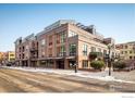 Exterior view of a modern, multi-story residential building with balconies, street access, and wintery street at 1360 Walnut St # 204, Boulder, CO 80302