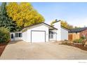 Inviting single-story home with a garage and lush trees in the background at 1513 Atwood St, Longmont, CO 80501