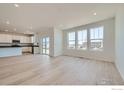 Bright open concept living room with hardwood floors next to kitchen with stainless steel appliances at 170 Fremont Ct, Brighton, CO 80601