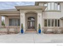 Elegant front entry with a leaded glass door, blue planters, and stucco detailing at 2035 Buchanan Pt, Lafayette, CO 80026
