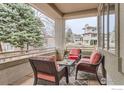 Cozy covered porch features comfortable seating and views of the landscaped backyard at 2035 Buchanan Pt, Lafayette, CO 80026