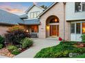 Inviting front entrance with a brick archway and lush landscaping at 2245 Ridgeview Way, Longmont, CO 80504