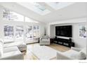 Bright living room with a skylight, large windows, light gray furniture, and hardwood floors at 3590 Longwood Ave, Boulder, CO 80305