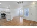 Bright, open-concept living space featuring hardwood floors and a modern island kitchen at 3648 Oakwood Dr, Longmont, CO 80503