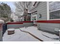 Townhome side entrance with a cute barrel decoration and a light covering of snow at 3648 Oakwood Dr, Longmont, CO 80503