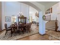 Elegant dining room with hardwood floors, a large chandelier, and staircase at 5385 Dunraven Cir, Golden, CO 80403