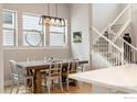 Dining area with modern light fixture, concrete table, and staircase access at 6334 N Dayton Way, Denver, CO 80238
