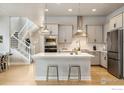 Open kitchen layout with island seating, stainless appliances, and stylish white cabinetry at 6334 N Dayton Way, Denver, CO 80238