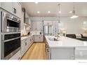 Modern kitchen featuring stainless steel appliances, white countertops, and sleek gray cabinets at 6334 N Dayton Way, Denver, CO 80238