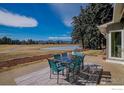 Inviting back patio with outdoor dining set overlooking a serene golf course and mountain view at 7034 Indian Peaks Trl, Boulder, CO 80301