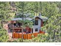 Modern home nestled in the trees with a spacious deck and fenced-in patio area at 795 Pine Brook Rd, Boulder, CO 80304