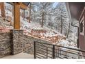 Inviting exterior view with stonework and metal railings with snow-covered landscaping at 795 Pine Brook Rd, Boulder, CO 80304