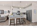 Modern kitchen featuring white cabinetry, granite countertops, and stainless steel appliances at 167 Ambrose St, Erie, CO 80516