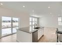 Modern kitchen island with sink, stainless steel dishwasher, and sliding glass door to the backyard at 189 Baler Ct, Brighton, CO 80601