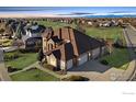 Expansive home with a three-car garage and manicured lawn set against a backdrop of neighborhood greenery at 1949 Wasach Dr, Longmont, CO 80504