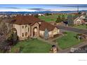 Stunning two-story home showcasing a manicured lawn, stone details, and views of the Rockies at 1949 Wasach Dr, Longmont, CO 80504