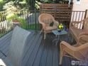 Relaxing back deck featuring stylish wicker furniture and a verdant garden view at 2042 Garfield Ave, Louisville, CO 80027