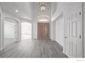 Bright foyer with soaring ceilings, chandelier, hardwood floors, and large double doors at 301 Amethyst Way, Superior, CO 80027