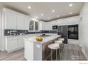 Modern kitchen features white cabinets, gray backsplash, large island, and stainless steel appliances at 301 Amethyst Way, Superior, CO 80027